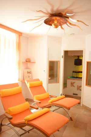 Ruhebereich mit Kräutersauna im Hintergrund Ruhebereich mit Kräutersauna im Hintergrund